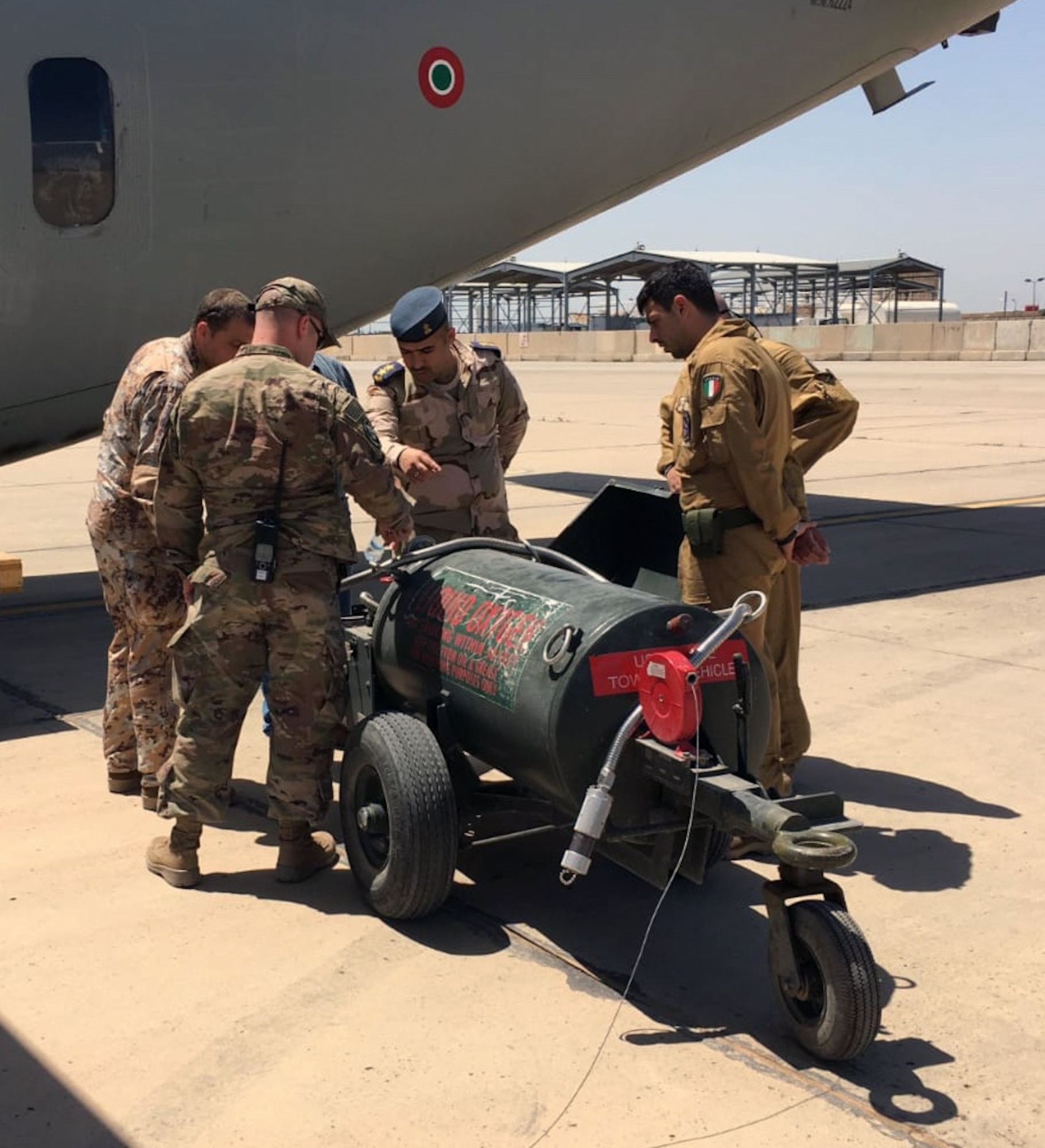 (L-R) Senior Master Sgt. Tim Smith and Master Sgt. Brian Osman, air advisors assigned to the 770th Air Expeditionary Advisory Squadron, and Iraqi Air Force 1st Lt. Alaa Aziz, oxygen officer, watch an Iraqi maintenance airman fill up a tank with liquid oxygen May 22, 2018, at Al Muthana Air Base in Baghdad, Iraq. (U.S. Air Force photo by Capt. Benjamin Hughes)