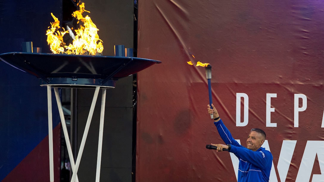 A retired airman lights the torch opening the 2018 Warrior Games.