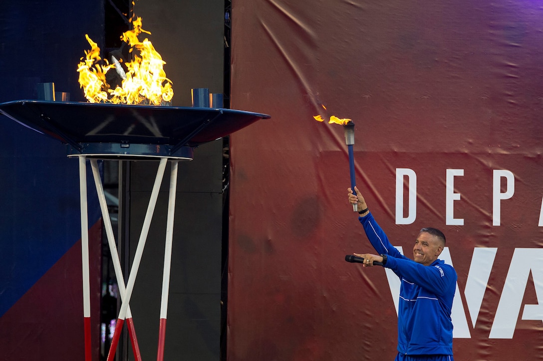 A retired airman lights the torch opening the 2018 Warrior Games.