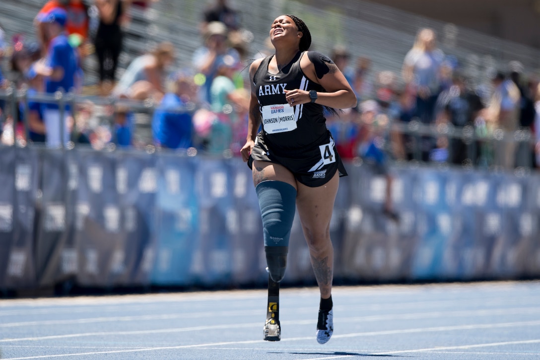 A female athlete finishes a race with a grimace on her face.