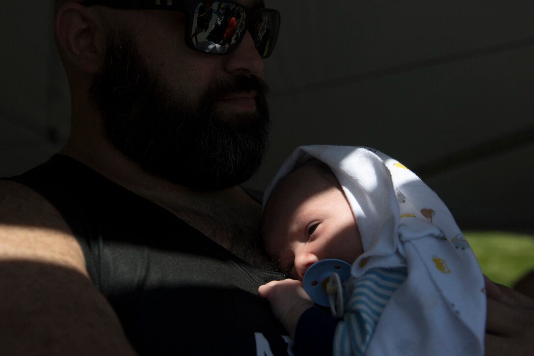 Army Sgt. David Crook holds his 1-month-old son, Alexander, during the 2018 Defense Department Warrior Games.