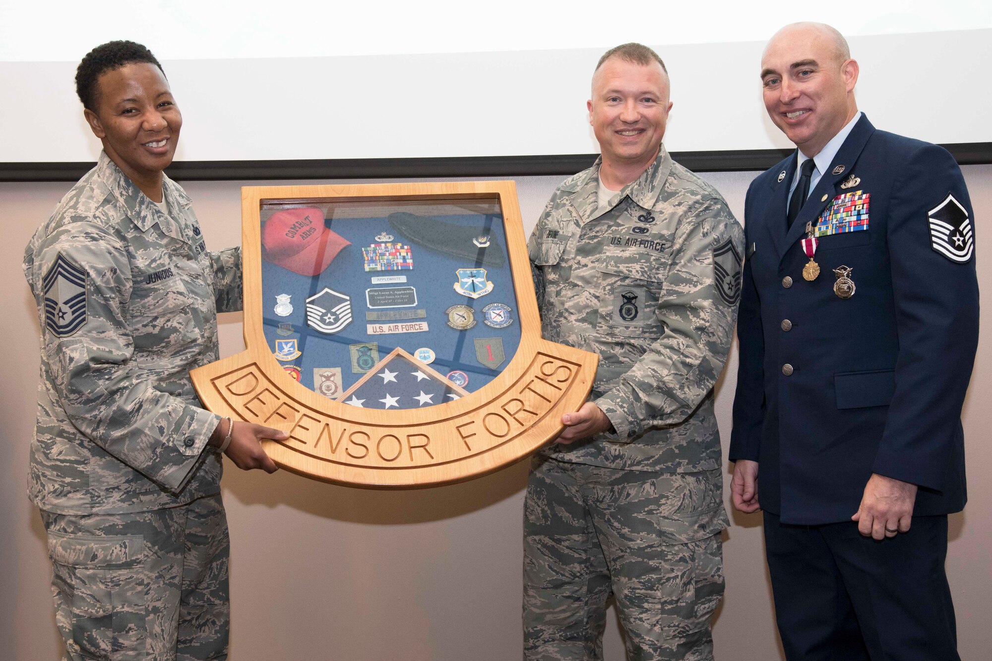 Master Sgt. Lucas Applewhite (right), 403rd Security Forces Squadron senior active reservist and security forces action officer, receives a shadow box with items reflecting various points of his career from security forces members at his retirement ceremony June 2, 2018, at Keesler Air Force Base, Mississippi. Lucas retired from the U.S. Air Force Reserve after serving in the military for 21 years, all of which were with the Air Force and security forces. (U.S. Air Force photo by Tech. Sgt. Ryan Labadens)