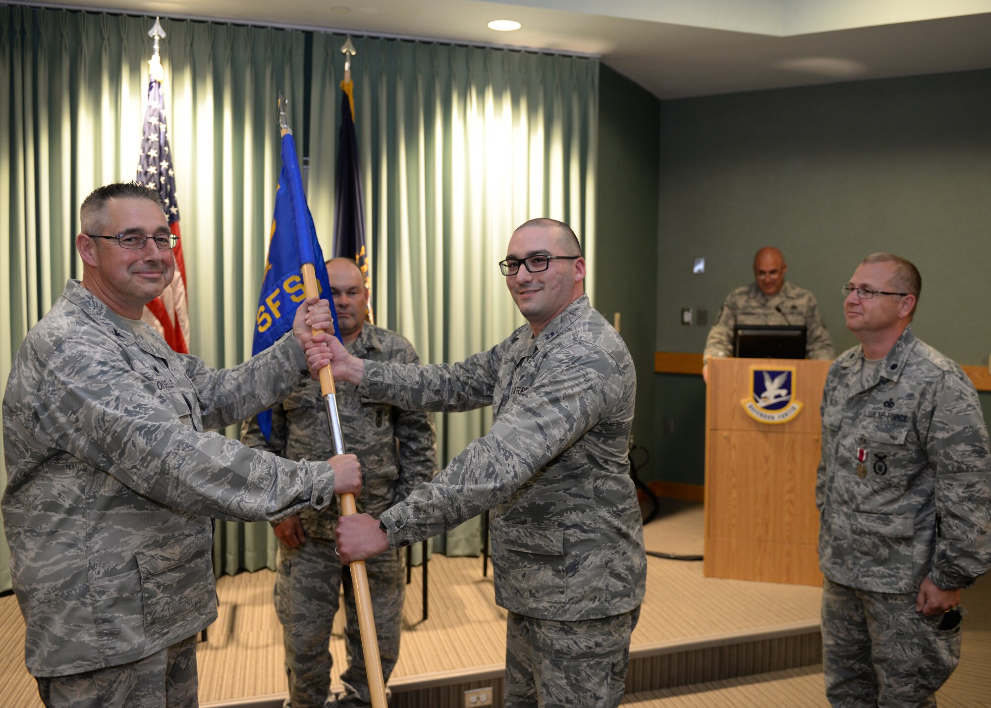 Col. Paul N. Loiselle, 157th Mission Support Group commander, left, receives the 157th Security Forces Squadron guidon from Capt. Aaron C. McCarthy, 157th SFS incoming commander during a ceremony at Pease Air National Guard Base, N.H., June 2, 2018.  McCarthy assumed command of the squadron from Lt. Col. Jassen L Bluto, outgoing commander.  (N.H. Air National Guard photo by Staff Sgt. Curtis J. Lenz)