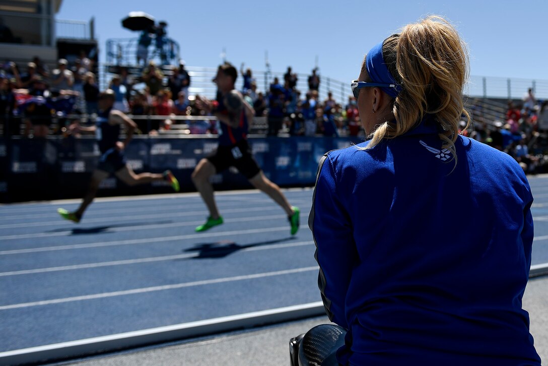 A service member watches her fellow wounded warriors participate in the   track and field competition.