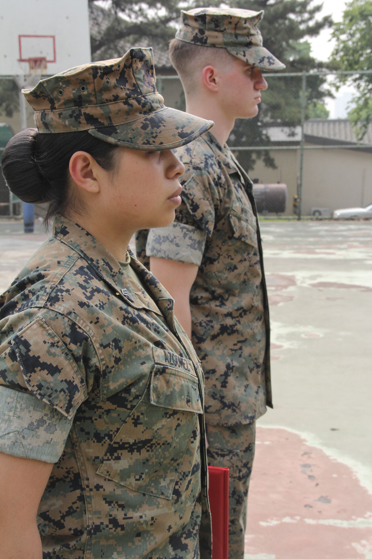 Sgt. Norma Azgomez (front), U.S. Marine Corps Forces Korea G1 non-commissioned officer in charge, and Lance Cpl. Marcus A. Whited, MARFORK G6 help-desk clerk, stand at the position of attention during their ceremony here, May 14. Both Marines received a Certificate of Commendation; Azgomez for being selected NCO of the Quarter, and Whited for being selected Marine of the Quarter. (U.S. Marine Corps photo by Staff Sgt. Anthony Kirby/Released)
