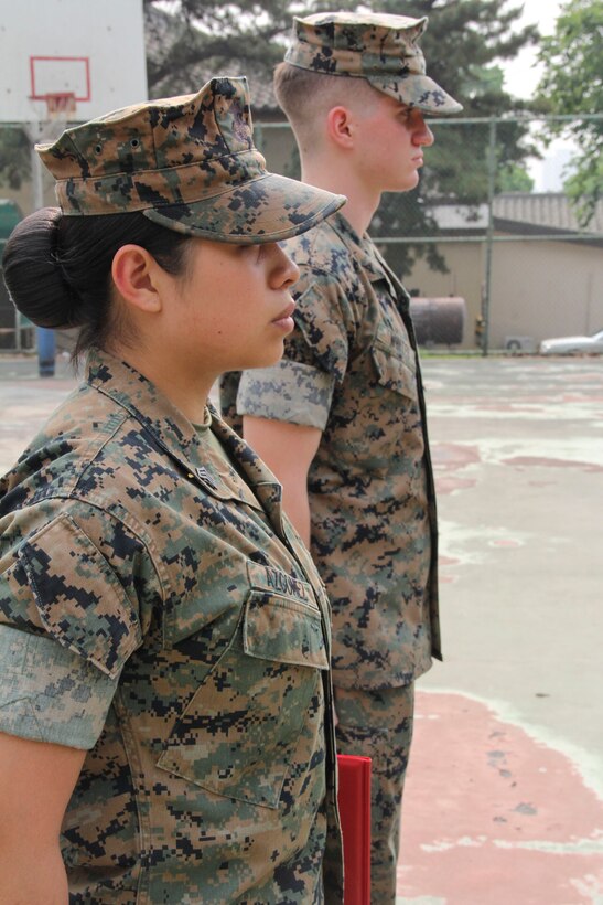 Sgt. Norma Azgomez (front), U.S. Marine Corps Forces Korea G1 non-commissioned officer in charge, and Lance Cpl. Marcus A. Whited, MARFORK G6 help-desk clerk, stand at the position of attention during their ceremony here, May 14. Both Marines received a Certificate of Commendation; Azgomez for being selected NCO of the Quarter, and Whited for being selected Marine of the Quarter. (U.S. Marine Corps photo by Staff Sgt. Anthony Kirby/Released)