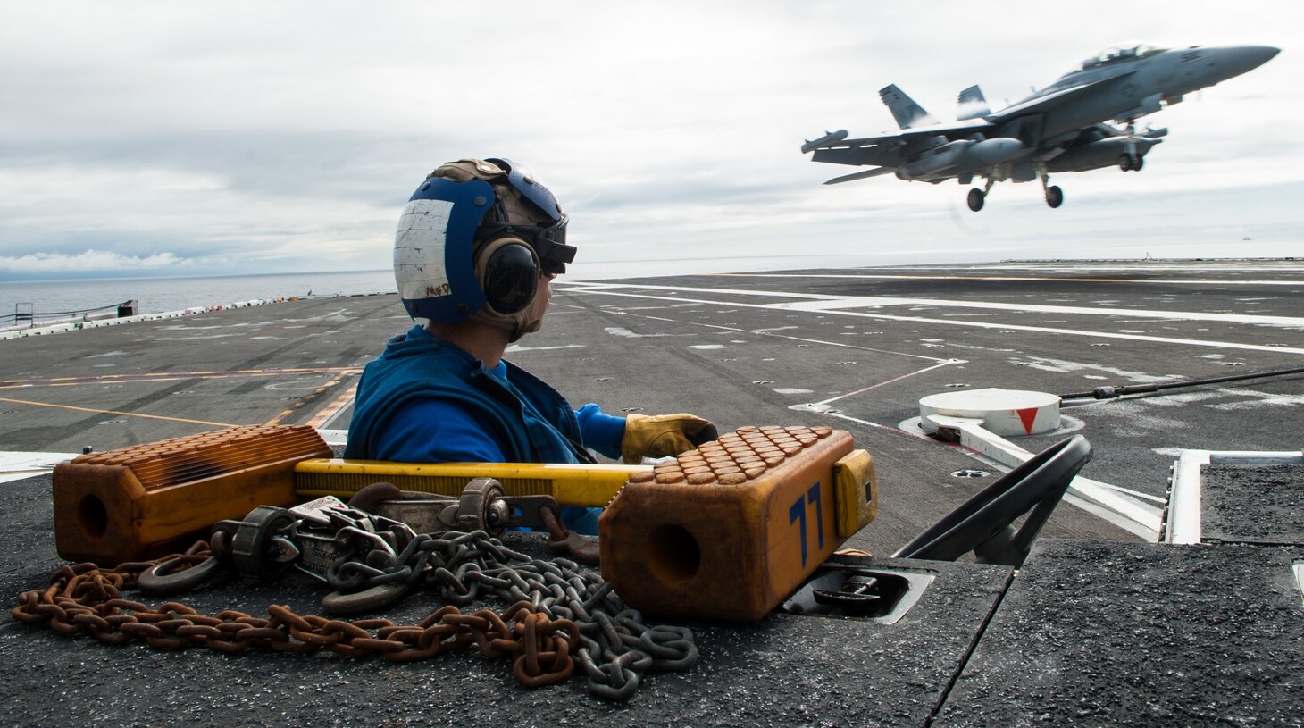 Aviation Boatswain's Mate Airman Alexander Dooley, from Bradenton, Florida, observes an EA-18G Growler, assigned to Strike Fighter Squadron (VAQ) 141, as it lands on the flight deck during carrier qualifications with the Navy's forward-deployed aircraft carrier, USS Ronald Reagan (CVN 76), and Carrier Air Wing 5. Ronald Reagan, the flagship of Carrier Strike Group 5, provides a combat-ready force that protects and defends the collective maritime interests of its allies and partners in the Indo-Pacific region.