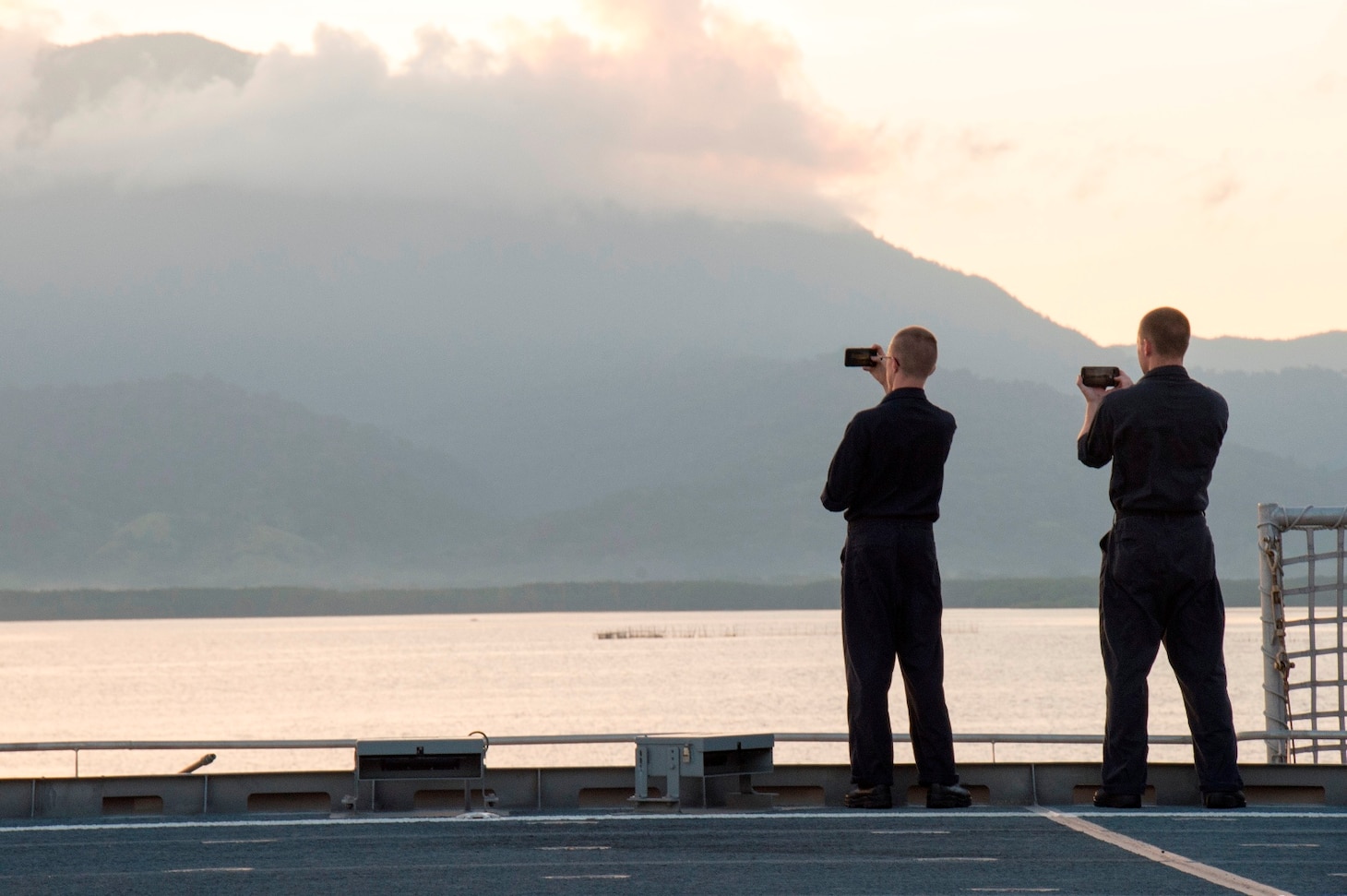 Musician 3rd Class Ian Cooper (left) and Musician 2nd Class Brian Kloppenburg (right) take a photos as USNS Millinocket (T-EPF 3) pulls into Puerto Princesa during a U.S. 7th Fleet theater security cooperation patrol. More than 40 members of the 7th Fleet staff are currently embarked on Millinocket visiting several countries in the Indo-Pacific region.
