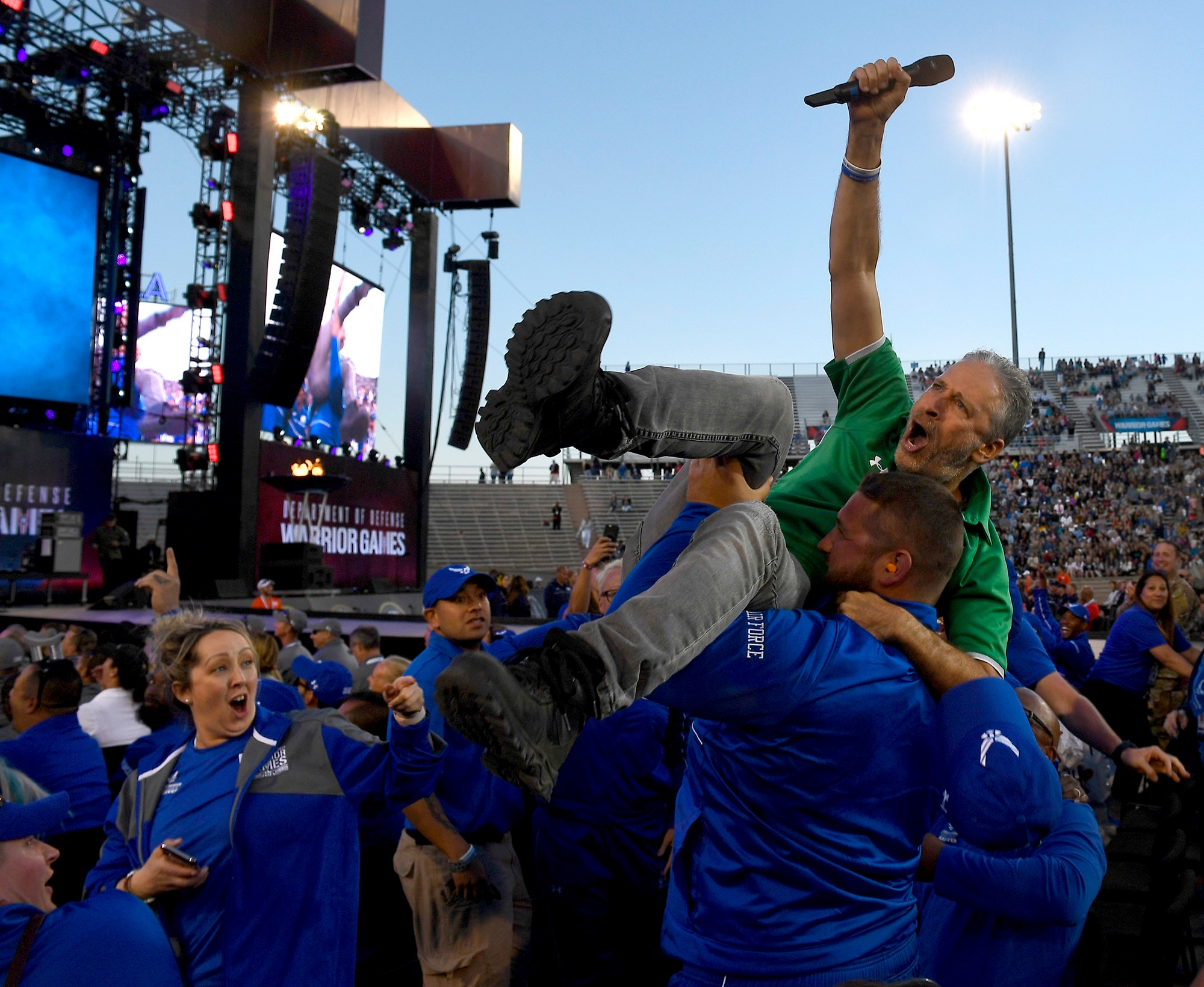 Actor and television personality Jon Stewart is hoisted up in the air by members of Team Air Force during the opening ceremony of the Department of Defense Warrior Games at the U.S. Air Force Academy in Colorado Springs, Colorado, June 2, 2018. First held in Colorado Springs in 2010, the Warrior Games were established as a way to expose service members who were wounded, ill or injured to adaptive sports. The Air Force is the host service for this year's Games. (U.S. Air Force photo by Staff Sgt. Rusty Frank)