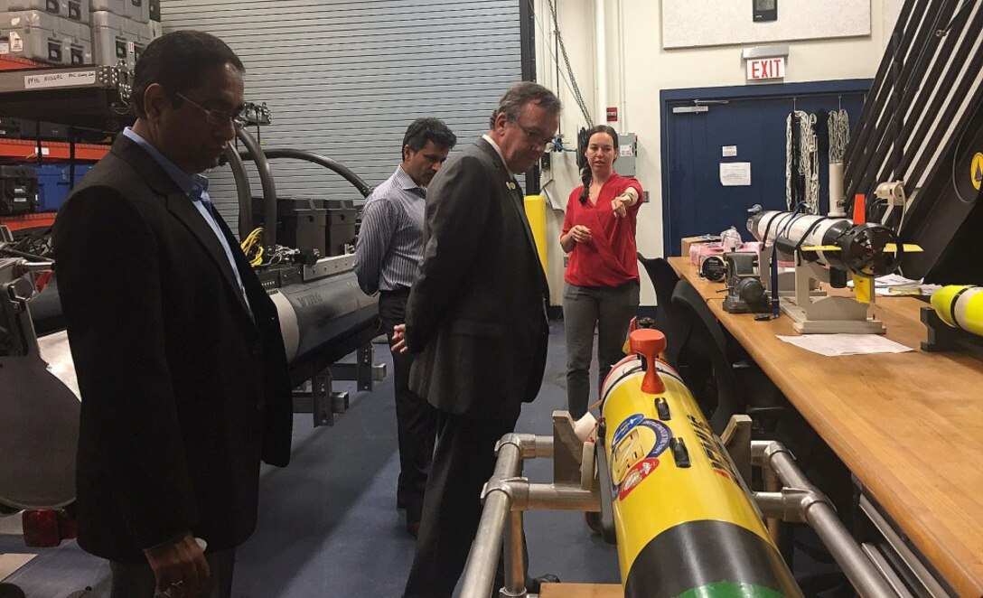 Five Florida Agricultural and Mechanical University and Florida State University (FAMU-FSU) College of Engineering deans visited Naval Surface Warfare Center Panama City Division (NSWC PCD) June 1, 2018. The deans met with NSWC PCD leadership and project leads, like Amanda Bobe featured here, to learn about the Division's technical capabilities. Bobe, assigned to NSWC Panama City Division, explains unmanned systems and NSWC PCD's role in the Naval Unmanned Systems Shared Resource Center. Featured here is, from left to right, Associate Dean for Research and Graduate Studies Dr. Farrukh Alvi, Associate Professor, Mechanical Engineering, Dr. Rajan Kumar, and Dean of Engineering Dr. John M. Gibson. (RELEASED) U.S. Navy photo by Susan H. Lawson.