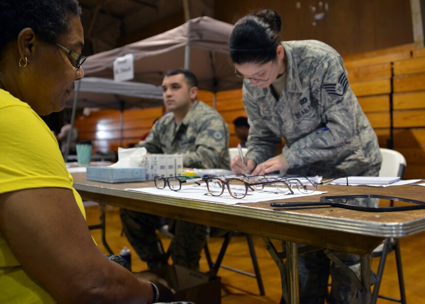 U.S. Air Force Staff Sgt. Jay Griggs (left) assigned to the Aeromedical Staging Squadron and Staff Sgt. Leslie Hamill assigned to the 166th Medical Group, acting medical technician augmentees, assist optometry patients with selecting eyeglasses during Operation Empower Health - Savannah at the Garden City Recreational Center, Garden City, Ga., May 10, 2018. (U.S. Air National Guard photo by Senior Airman Jamila A. Haven)
