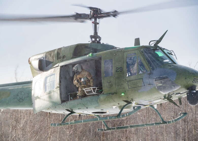 A U.S. Air Force UH-1N Iroquois with the 54th Helicopter Squadron, Minot Air Force Base, North Dakota, hovers over the Turtle Mountain State Forest, North Dakota, Feb. 14, 2018, during a 91st Security Forces Group field training exercise. During the exercise, defenders vectored the aircraft to a landing zone and performed a simulated medical evacuation. (U.S. Air Force photo by Senior Airman J.T. Armstrong)