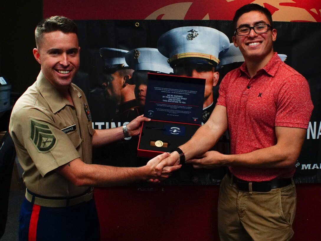 SSgt. Michael Donahue, recruiter from recruiting substation Wesley Chapel, presents Nicholas Verstegui his Semper Fi All American Program invitation kit at RSS Wesley Chapel, Florida, June 1, 2018.