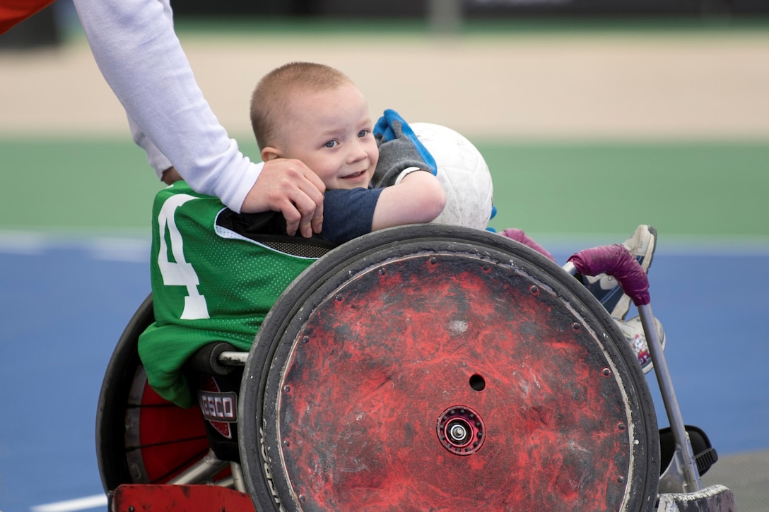 Cohen Schwab, 5, gets a push in a rugby wheelchair during an exhibition day for families during the 2018 Defense Department Warrior Games at the U.S. Air Force Academy in Colorado Springs, Colo., June 3, 2018. DoD photo by EJ Hersom