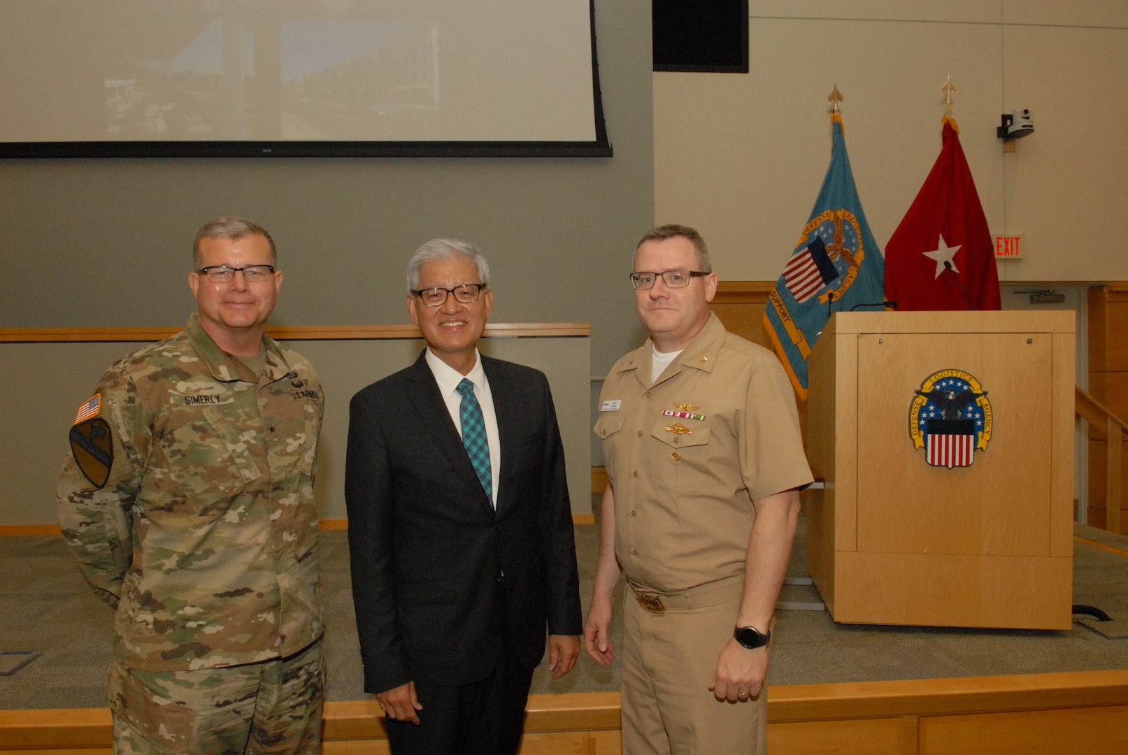 DLA Troop Support Commander Army Brig. Gen. Mark Simerly, left, poses with Asian American Pacific Islander Heritage Month event guest speaker Timothy Haahs, an architect, engineer and entrepreneur, and NAVSUP Weapons Systems Support Deputy Commander Navy Capt. David Ludwa May 24, 2018. During the event Haahs discussed his experiences growing up in a leper colony in South Korea, coming to the U.S. when he was 12 years old, receiving two heart transplants and becoming a U.S. Senate confirmed appointee to the Board of Directors of the National Institute of Building Sciences. Photo by Ed Maldonado