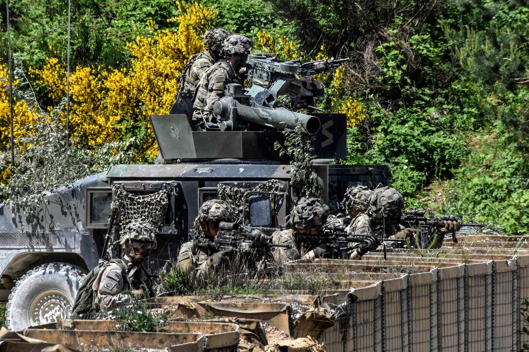 Soldier scan their sectors of fire during a live-fire exercise.