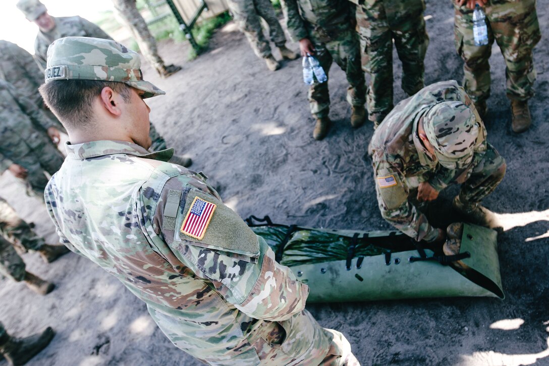 A soldier supervises another soldier during combat lifesaver training.