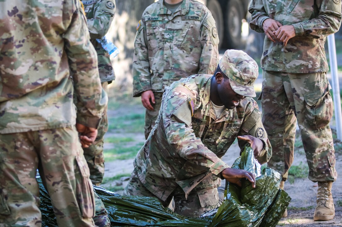 A group of soldiers prepare a casualty for transport.