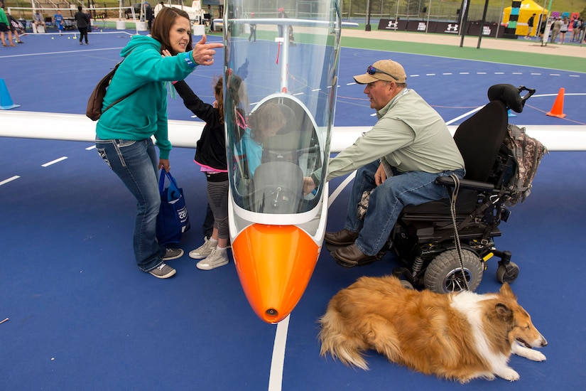 Three people look at a piece of sporting equipment.