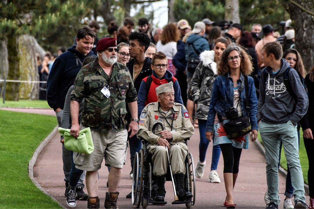 Family members and friends walk with World War II veteran Robert Wallace.