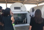 Employees view a process at a military air base.