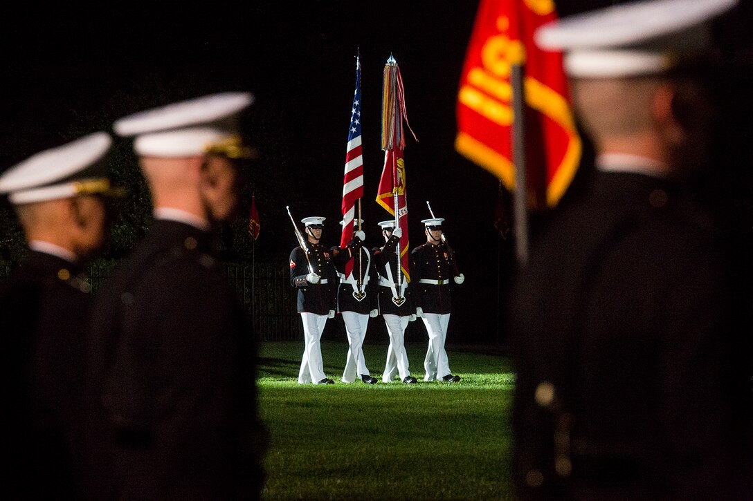 Marines with the U.S. Marine Corps Color Guard march the National Ensign and U.S. Marine Corps Battle Colors onto the parade deck during the Friday Evening Parade at Marine Barracks Washington, June 1, 2018. The hosting official for the parade was Lt. Gen. Rex McMillian, commanding general, Marine Forces Reserve and Marine Forces North, and the guest of honor was retired Lt. Gen. Robert M. Shea, chairman of Marine Toys for Tots Foundation Board of Directors and president and CEO of the Armed Forces Communications and Electronics Association. (Official Marine Corps photo by Sgt. Robert Knapp/Released)