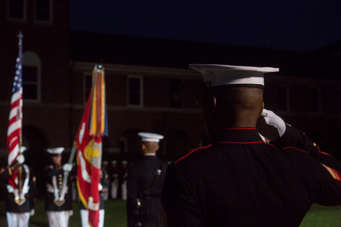 Sgt. Julian Moore, parade marching staff, renders a salute during the playing of the National Anthem during the Friday Evening Parade at Marine Barracks Washington, June 1, 2018. The hosting official for the parade was Lt. Gen. Rex McMillian, commanding general, Marine Forces Reserve and Marine Forces North, and the guest of honor was retired Lt. Gen. Robert M. Shea, chairman of Marine Toys for Tots Foundation Board of Directors and president and CEO of the Armed Forces Communications and Electronics Association. (Official Marine Corps photo by Sgt. Robert Knapp/Released)