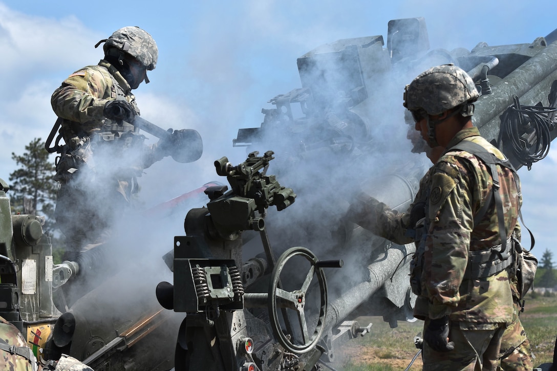Soldiers clear a M777 howitzer after conducting a live-fire mission.