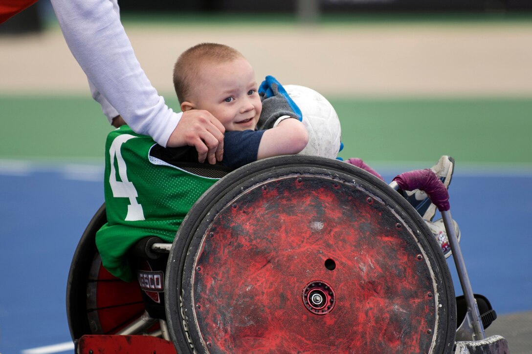 Cohen Schwab gets a push in a rugby wheelchair.