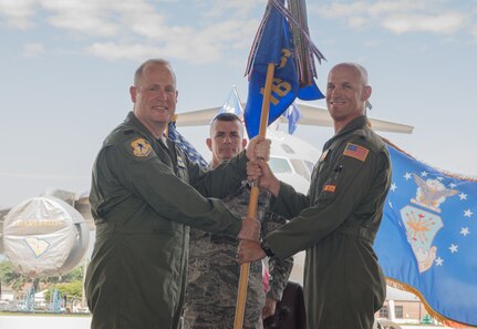 Lt. Col. Alex Pelbath, right, accepts the 16th Airlift Squadron guidon from Col. Louis Hansen, 437th Operations Group commander, during a change of command ceremony in Nose Dock 2 June, 1, 2018.