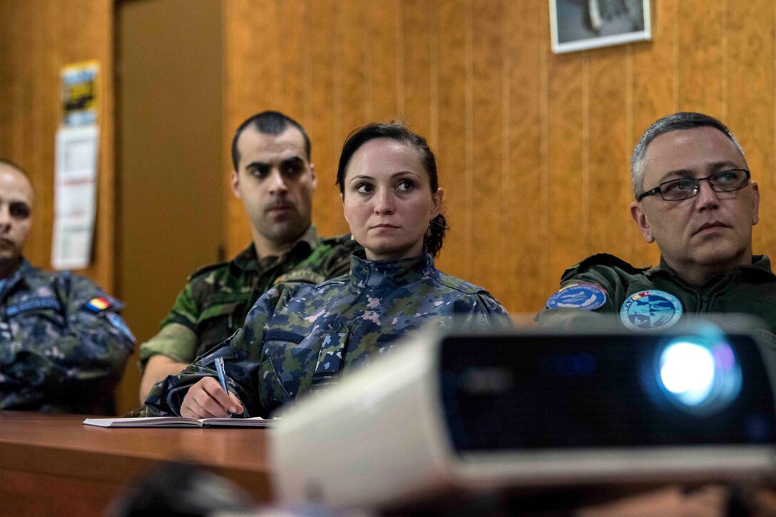 Romanian and Bulgarian air force personnel receive a briefing.