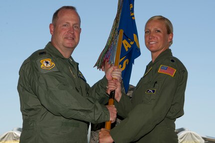 Lt. Col. Kari Fleming, right, accepts the 14th Airlift Squadron guidon from Col. Louis Hansen, 437th Operations Group commander, during a change of command ceremony in Nose Dock 2 June 4, 2018.