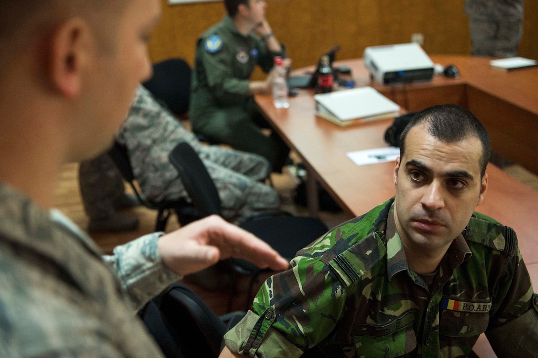 A U.S. airman talks tactical training techniques to a Bulgarian army soldier.