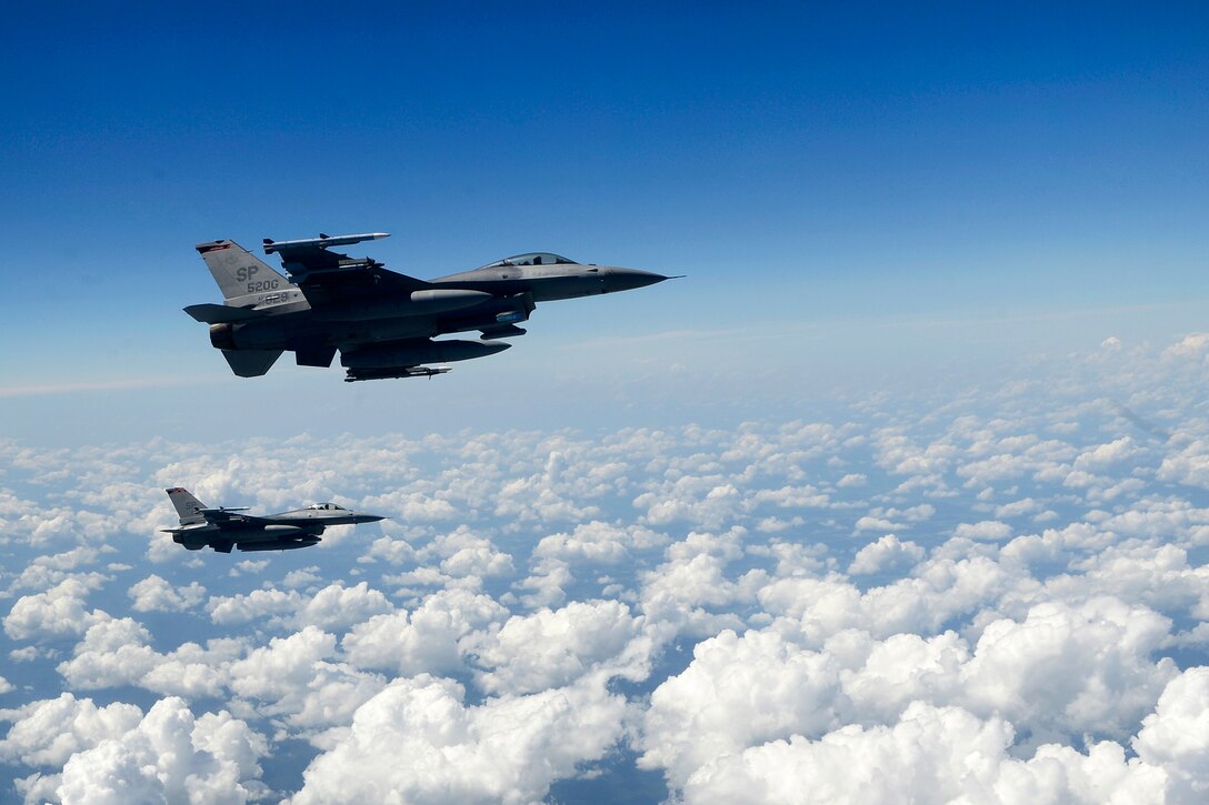 Two Air Force F-16 Fighting Falcons fly beside a KC-135R Stratotanker.