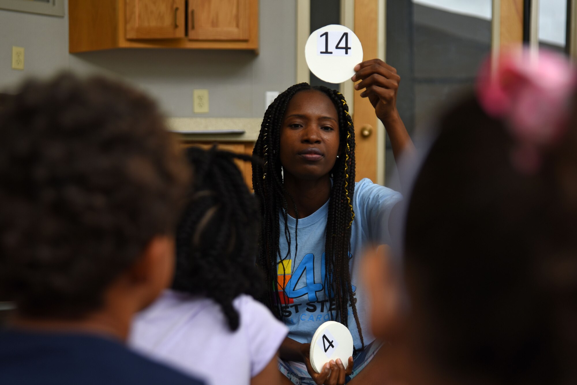 Yassah Kollie, 20th Force Support Squadron child and youth program lead, holds a card for her South Carolina First Steps 4K students to read at the Child Development Center at Shaw Air Force Base, S.C., May 31, 2018.