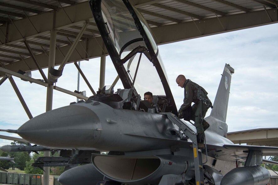 U.S. Air Force Lt. Col. Brandon McBrayer, 20th Operations Group deputy commander, climbs a ladder while a member of the Philippine Air Force sits in an F-16DM Fighting Falcon at Shaw Air Force Base, S.C., May 23, 2018.