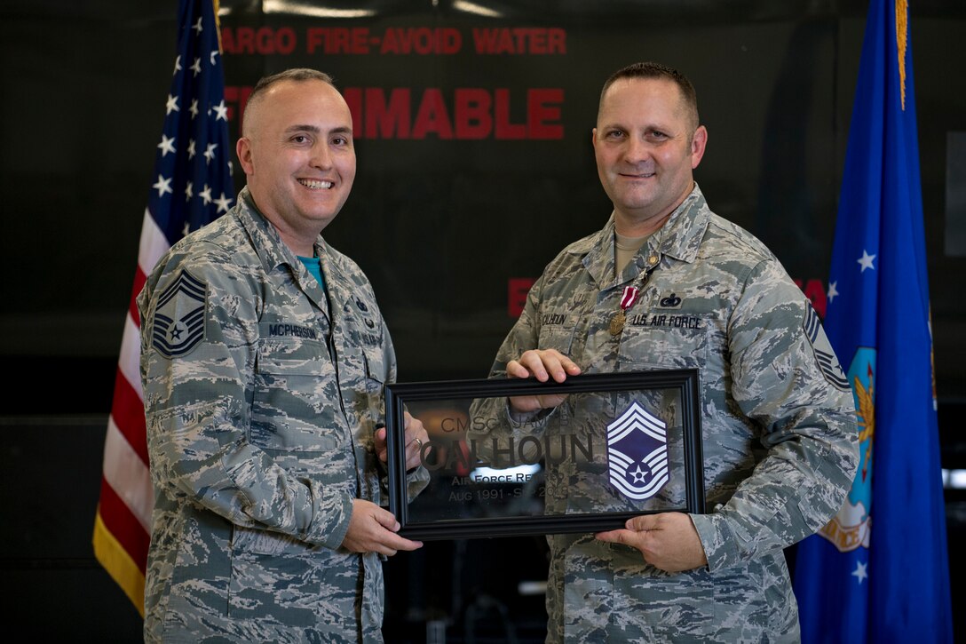 Chief Master Sgt. Bruce McPherson, 23d Mission Support Group (MSG) chief enlisted manager, presents a gift from the 23d MSG to Chief Master Sgt. Jim Calhoun, 23d Logistics Readiness Squadron superintendent, during Calhoun’s retirement ceremony, June 1, 2017, at Moody Air Force Base, Ga. Calhoun entered the Air Force in August of 1991 and served in numerous positions within fuels management and logistics readiness throughout his career. (U.S. Air Force photo by Senior Airman Daniel Snider)