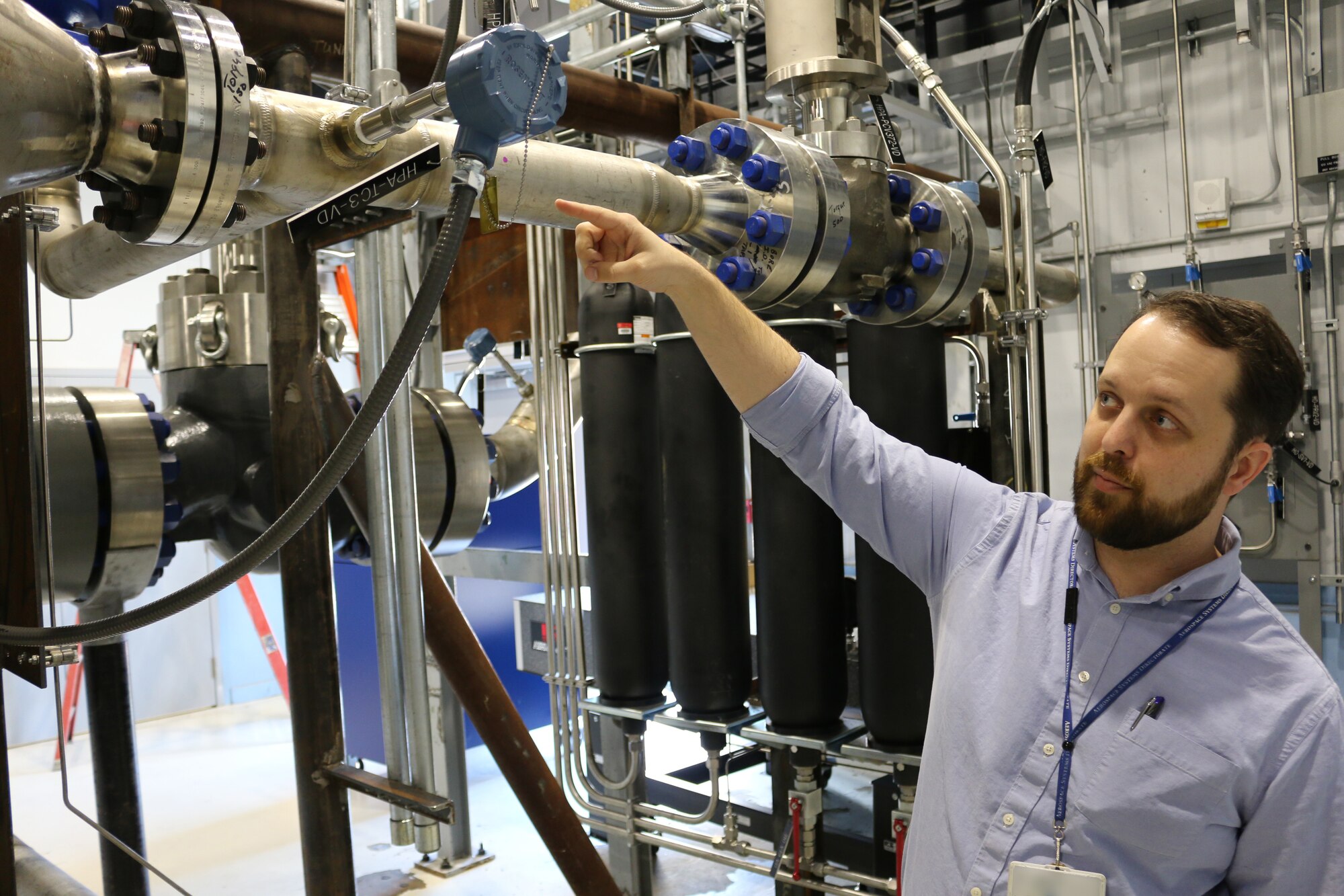 Dr. Jerrod Hofferth, the Air Force Research Laboratory technical lead on the Tunnel D reactivation project, discusses the operations of the von Kármán Gas Dynamics Facility Wind Tunnel D. The reactivation of the wind tunnel at Arnold Air Force Base is nearing completion after approximately 40 years of dormancy. (U.S. Air Force photo/Bradley Hicks) (This image was manipulated by obscuring badges for security purposes)