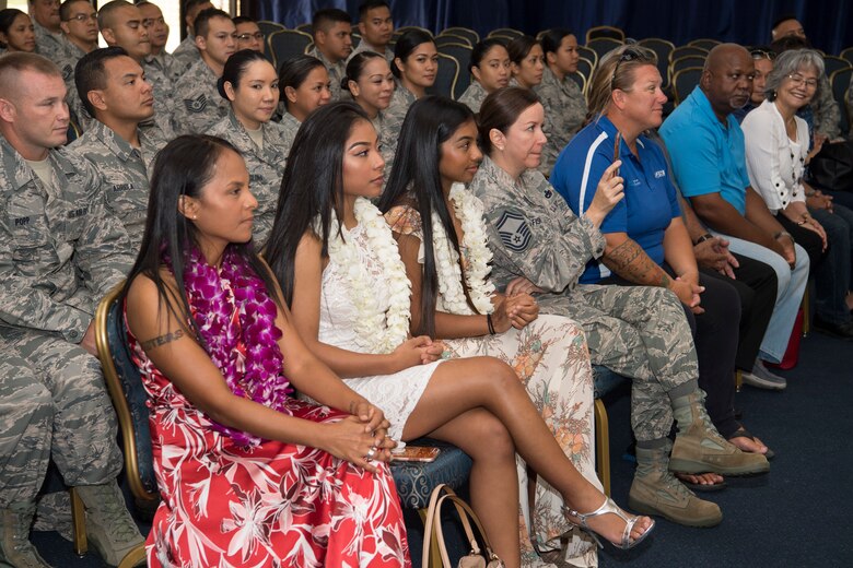 The family of U.S. Air Force Lt. Col. Carla Lugo, which include her wife, Tricia Topasna (left) along with their children, Asia Topasna, Sadie Topasna, and via video conference her Emilio Tullie and Stephanie Delgado attend her assumption of command of the 44th Aerial Port Squadron during a ceremony at Andersen Air Force Base, Guam, June 2, 2018, where Lugo became the squadron commander.