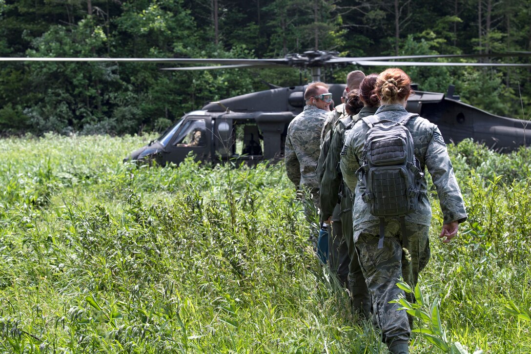 Airmen load onto a UH-60 Black Hawk helicopter.