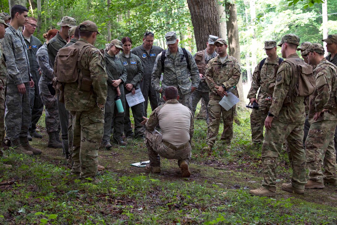 An instructor gives a mission brief to airmen before they participate in training.