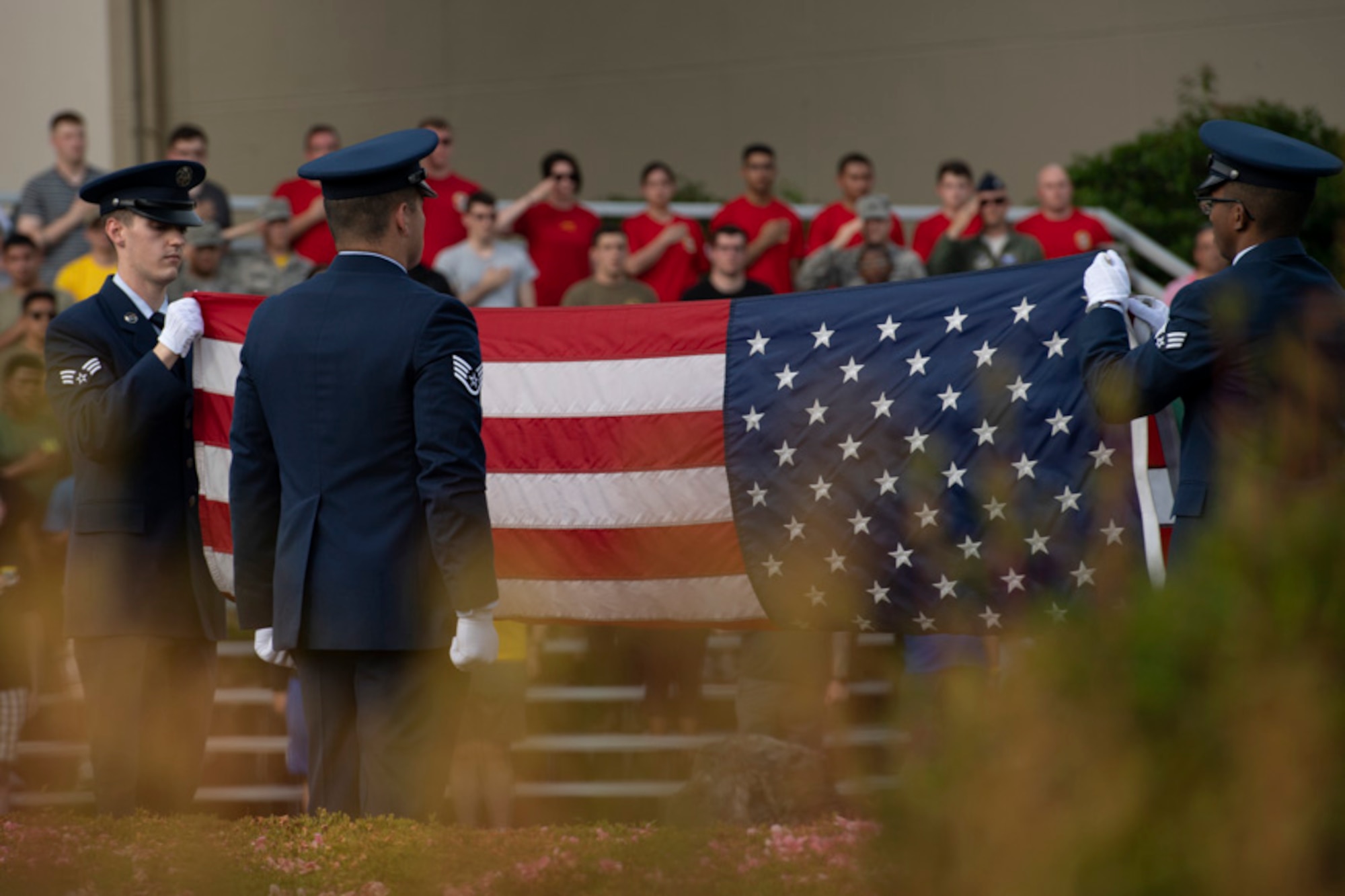 Yokota honor guardsmen fold an American flag during the Memorial Day ceremony