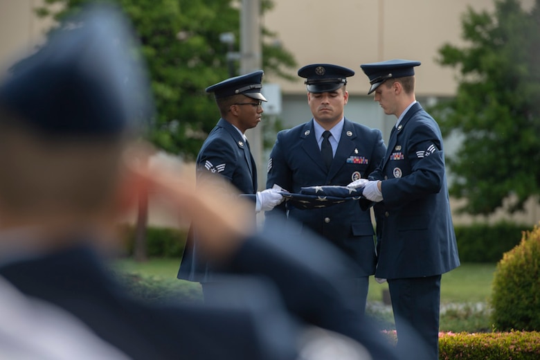 Yokota honor guardsmen fold an American flag during the Memorial Day ceremony