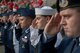 Service members salute during a ceremony for Memorial Day