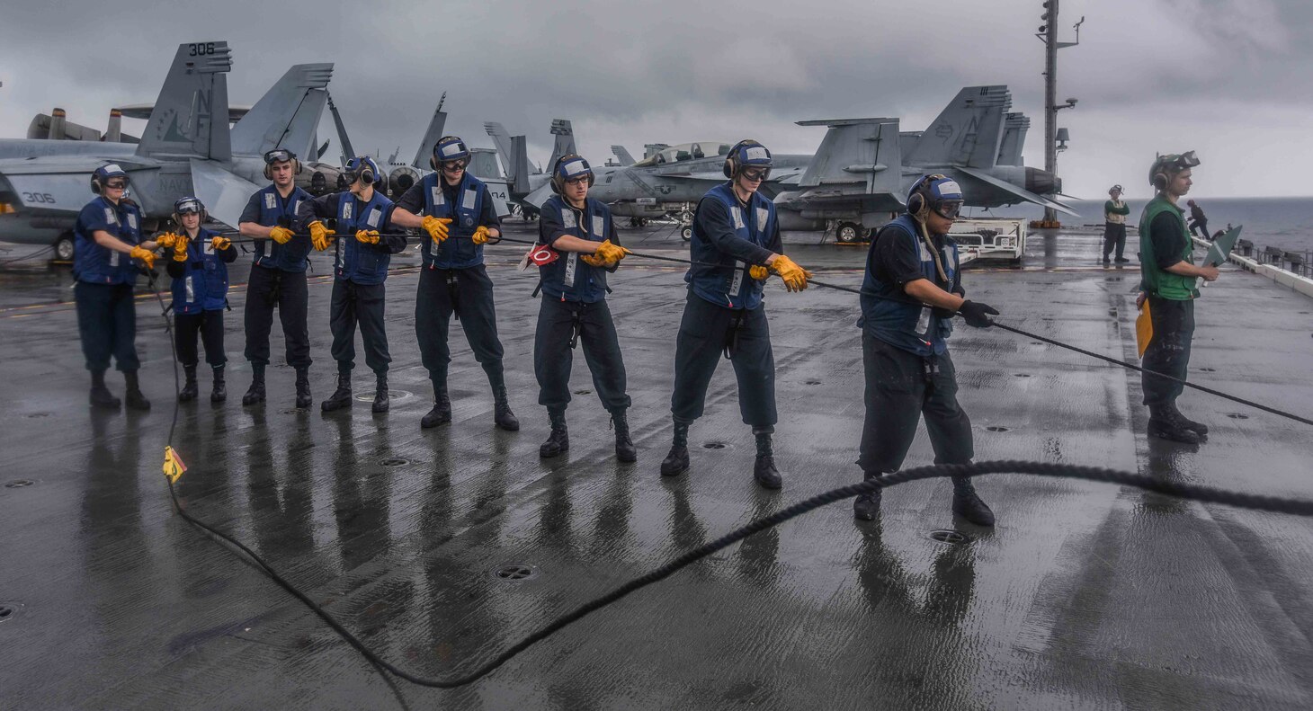 Midshipmen man the phone and distance line aboard the forward-deployed aircraft carrier, USS Ronald Reagan (CVN 76), during a replenishment at sea with the Military Sealift Command Dry Cargo and Ammunition Ship USNS Charles Drew (T-AKE 10)). Eighteen midshipmen are embarked aboard Ronald Reagan as part of a training program designed to familiarize the students with real-world shipboard operations. Ronald Reagan, the flagship of Carrier Strike Group 5, provides a combat-ready force that protects and defends the collective maritime interests of its allies and partners in the Indo-Pacific region.