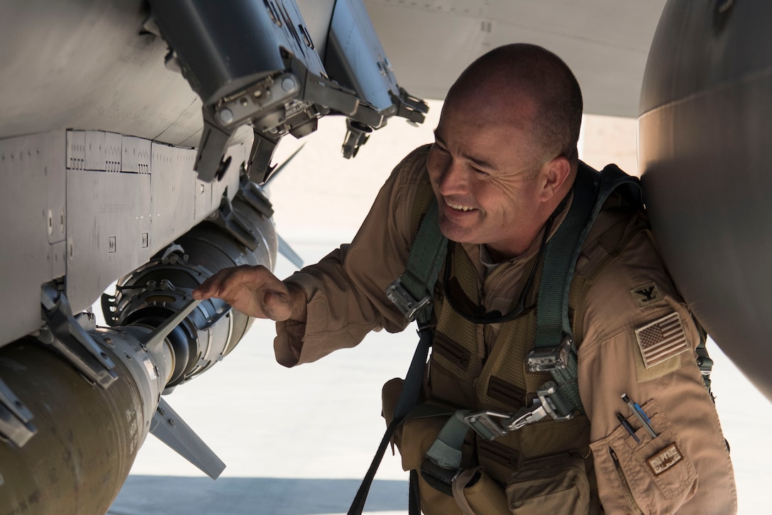 Col. William Marshall, 332nd Expeditionary Operations Group commander, smiles as he performs pre-flight checks on an F-15E Strike Eagle, June 2, 2018, at an undisclosed location in Southwest Asia.