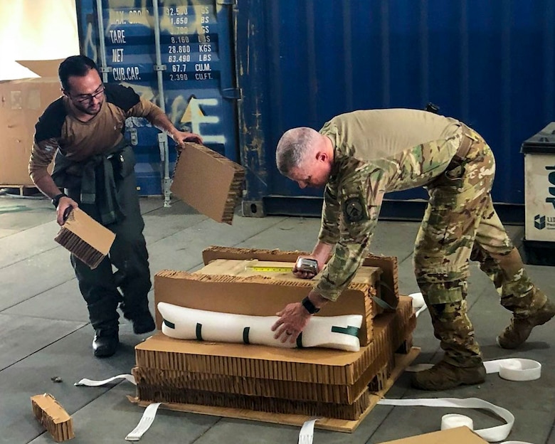 An Afghan Air Force loadmaster works with a Train Advise Assist Command Air Advisor to build a bundle for the AAF’s first emergency air drop June 1, 2018 Kabul Air Wing, Afghanistan.