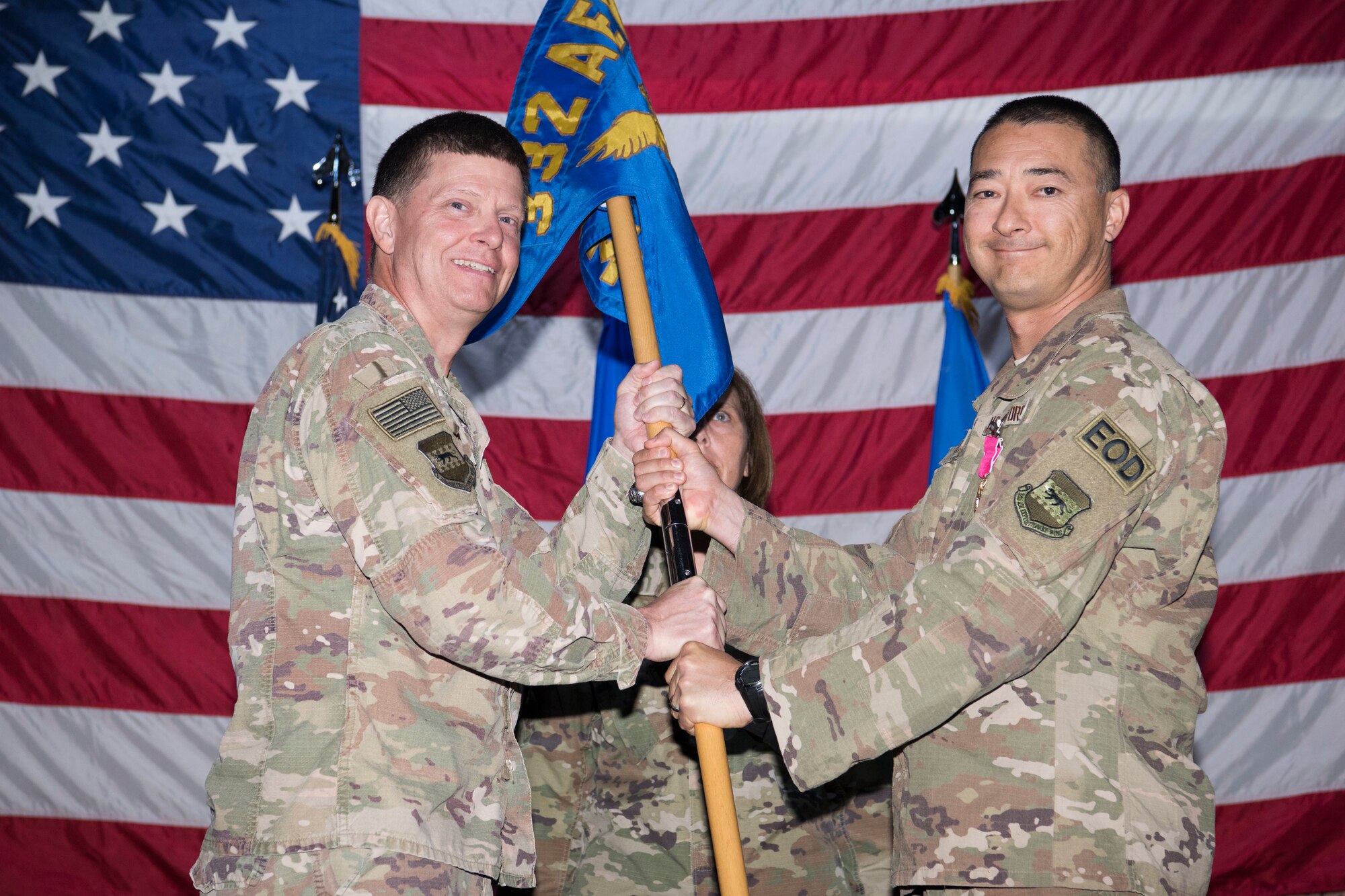 Brig. Gen. Kyle Robinson (left), 332nd Air Expeditionary Wing commander, takes the guidon from Col. Christopher Fuller, 332nd Expeditionary Mission Support Group commander, during the 332nd EMSG change of command, June 4, 2018, at an undisclosed location in Southwest Asia.