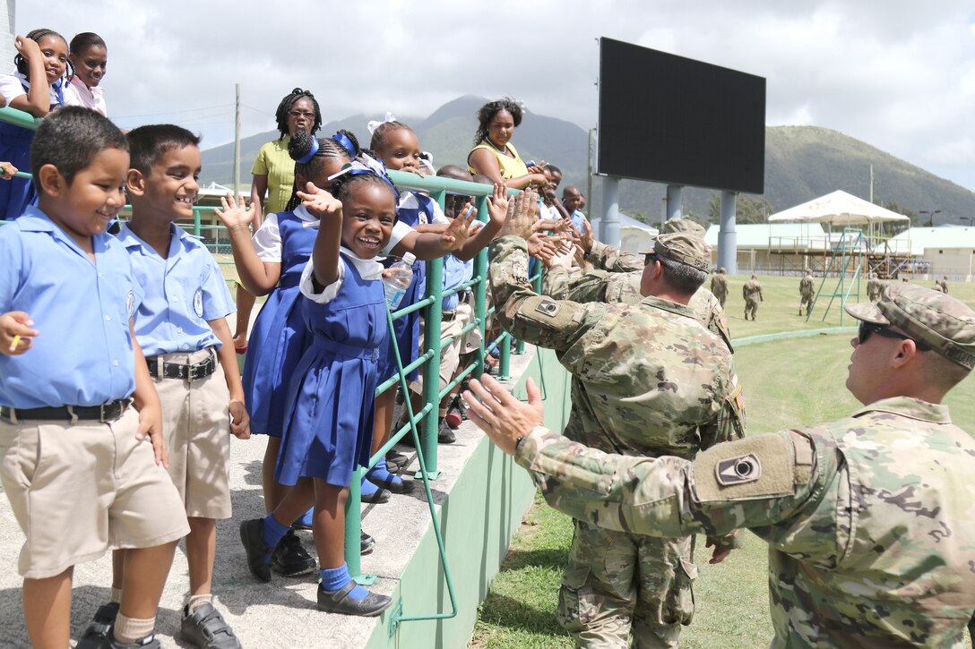 U.S. Army National Guard Soldiers greet school children.