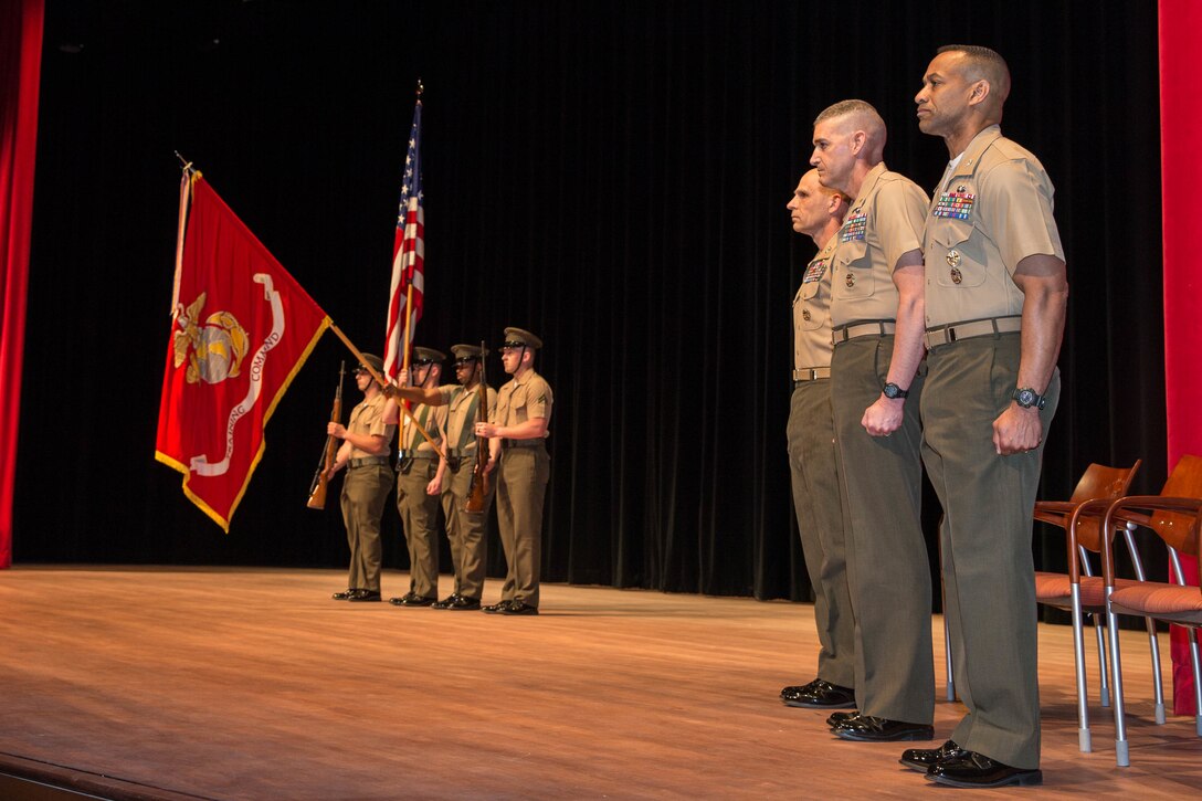 U.S. Marines with the official party stand at attention during the playing of the National Anthem during the Training Command change of command at Warner Hall, Marine Corps Base Quantico, Va., May 18, 2018. Brig. Gen. Jason Q. Bohm, outgoing commanding general (CG), Training Command, relinquished command to Col. Calvert Worth Jr., Brig. Gen. select, incoming CG, Training Command. (U.S. Marine Corps photo by Cpl. Brooke Deiters)